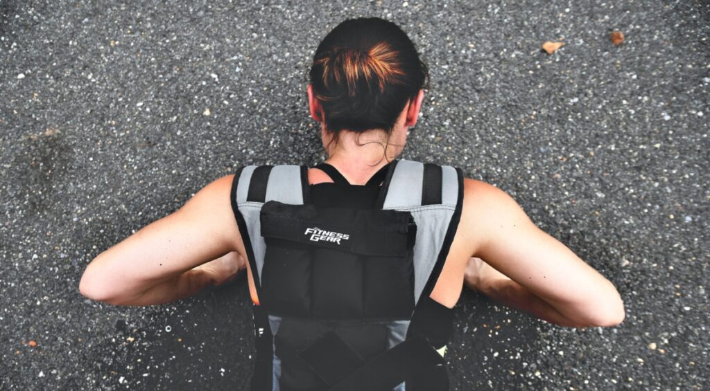Murph Workout for Beginners - woman doing push-ups in weighted vest on ground