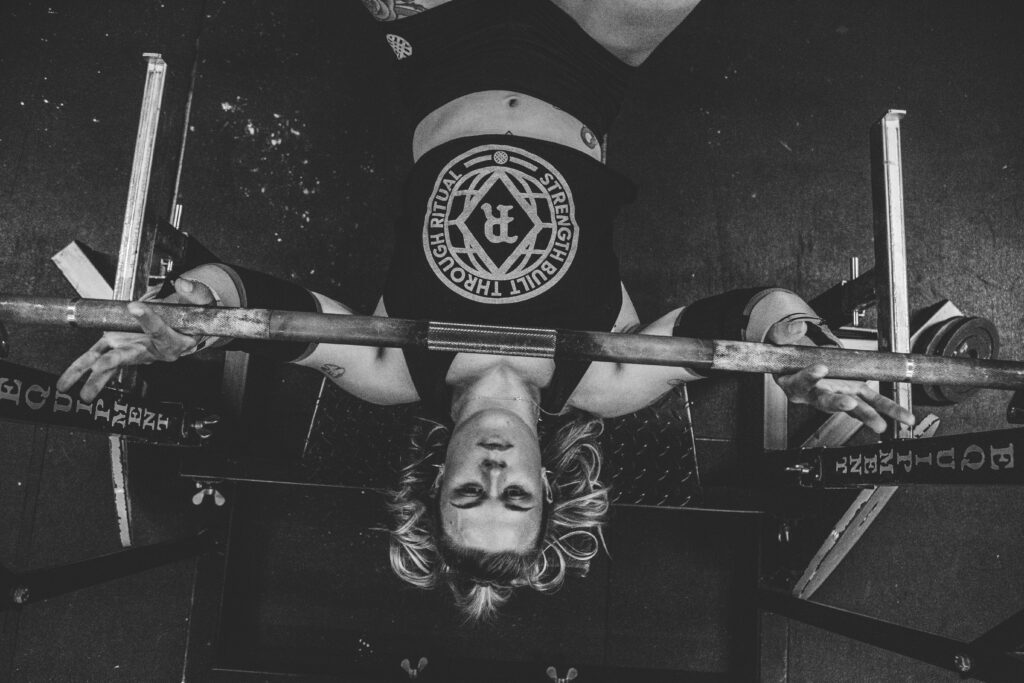 aerial view of woman performing bench press, demonstrating what is powerbuilding